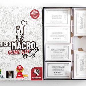 May include: A board game box titled "MicroMacro Crime City" with an open box revealing game cards. The box art features a city illustration and cartoon characters. The game cards are white with black text.