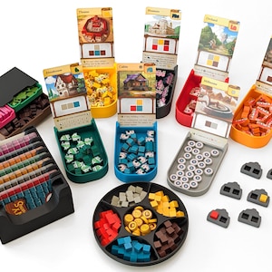 May include: A collection of board game components, including cards, tokens, and containers. The components are organized in various trays and boxes, with different colors and shapes. The game pieces include wooden cubes, cylinders, and other geometric shapes.
