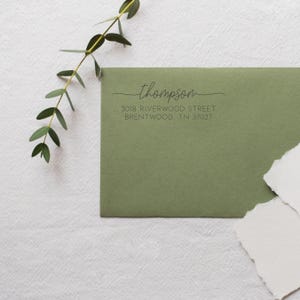 May include: A green envelope with a return address label that reads "thompson", "3018 Riverwood Street", "Brentwood TN 37027".