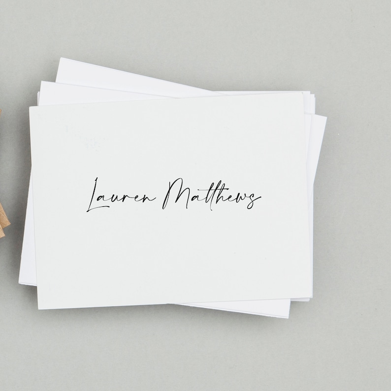 May include: A stack of white note cards with the name "Lauren Matthews" written in black cursive.