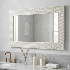 May include: A rectangular wall mirror featuring a wide frame with a repeating white and light gray geometric circular pattern. The mirror has a reflective glass surface that shows a partial view of a bathroom interior with a sink and accessories.