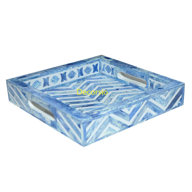 May include: A square serving tray with blue and white geometric patterns. The tray has two handles on the sides and a decorative border.