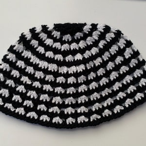 May include: Black and white crocheted kippah, a traditional Jewish head covering.