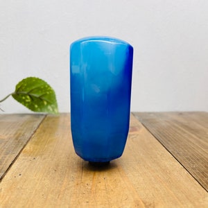 May include: A blue glass bottle stopper with a white swirl design.