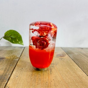 May include: A clear orange resin gear shift knob with a dried red rose inside.
