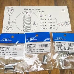 Pu&ograve; includere: Tre confezioni di viti adattatore per pomello del cambio in argento. Le confezioni sono etichettate con il testo "Vite adattatore per pomello del cambio" e le misure delle viti. Le misure sono 12x1,25 mm, 12x1,25 mm e 12x1,5 mm.