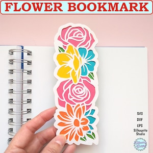 Peut inclure: Un marque-page fleuri coloré avec quatre fleurs en rose, jaune, bleu et orange. Le marque-page est découpé dans du papier cartonné blanc et est parfait pour ajouter une touche de fantaisie à n'importe quel livre.