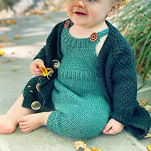 Könnte beinhalten: Ein grüner gestrickter Baby-Strampler mit einem Cardigan. Der Strampler hat einen runden Ausschnitt und einen Knopfverschluss auf der Rückseite. Der Cardigan hat einen Knopfverschluss auf der Vorderseite.