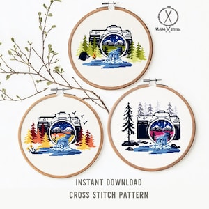 May include: Three cross-stitch patterns in wooden hoops, each featuring a black camera design with a landscape scene inside. The scenes include mountains, trees, and waterfalls. The text "INSTANT DOWNLOAD CROSS STITCH PATTERN" is at the bottom.
