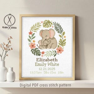 May include: A framed cross-stitch pattern featuring a mother and baby elephant surrounded by a floral wreath. The design includes the name "Elizabeth", date, time, weight (5lbs 15oz), and length (18in). The text "Digital PDF cross stitch pattern" is at the bottom.