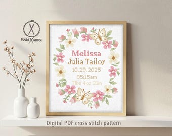 May include: Cross-stitch birth announcement framed in a light wood. The design features a floral wreath with butterflies, surrounding the name "Melissa Julia Tailor", birthdate, time, and weight. The text "Digital PDF cross stitch pattern" is at the bottom.