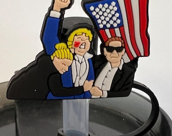 May include: A black, white, and red American flag is held by three cartoon figures. The figure on the left is wearing a black suit, the figure in the middle is wearing a blue suit, and the figure on the right is wearing a black suit and sunglasses. The figures are attached to a black straw lid.