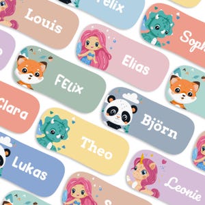 May include: A collection of colorful name tags with various illustrations, including a fox, mermaid, dinosaur, panda, and unicorn. Each tag features a different name in white text against a pastel background, perfect for labeling items.