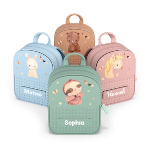 Può includere: Una collezione di zaini colorati per bambini. Ogni zaino presenta un'illustrazione di un animale diverso: un coniglio, un orso, un bradipo e un cavallo. Gli zaini sono nei toni del blu, marrone, rosa e verde, con i nomi "Matteo", "Sophia" e "Hannah" stampati.