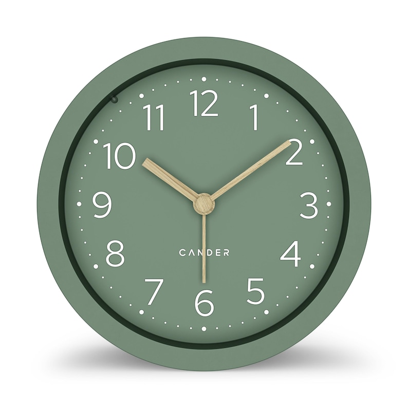 May include: A round, sage green analog clock with white numerals and a light wood-colored hour and minute hand. The clock face has a dotted minute track and the brand name "CANDER" is printed below the center.