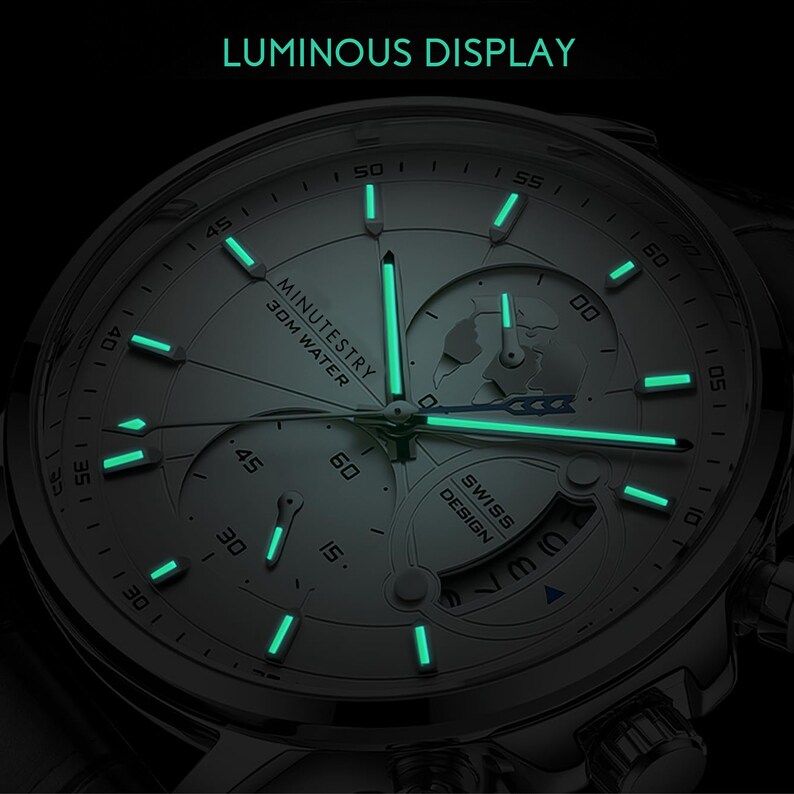 May include: A silver watch with a white face and luminous green hands and markers. The watch face features a small globe and the text "MINUTESTRY 30M WATER" and "SWISS DESIGN".