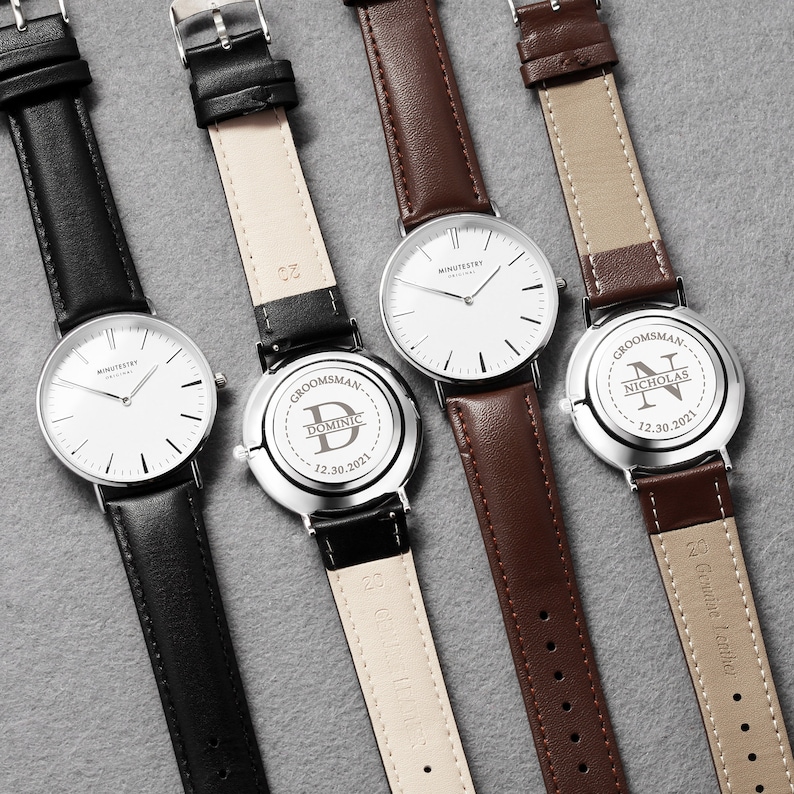 Set of engraved watches for groomsmen, featuring black and brown leather straps with personalized engravings on the back