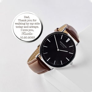 Personalized black-faced wristwatch with a brown leather strap, featuring a custom engraving on the back. Engraving reads: Dad, Thank you for walking by my side today and always. I love you, Kaitlin 10.20.2023