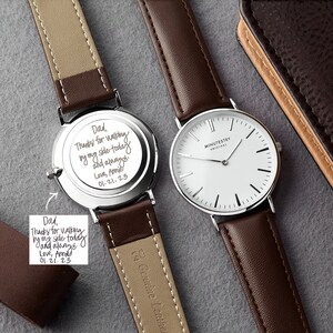 Wristwatch with a brown leather strap, alongside a personalized engraving on the back. The engraving is custom handwritten and reads: Dad, Thanks for walking by my side today and always. Love, Annie 01.21.23