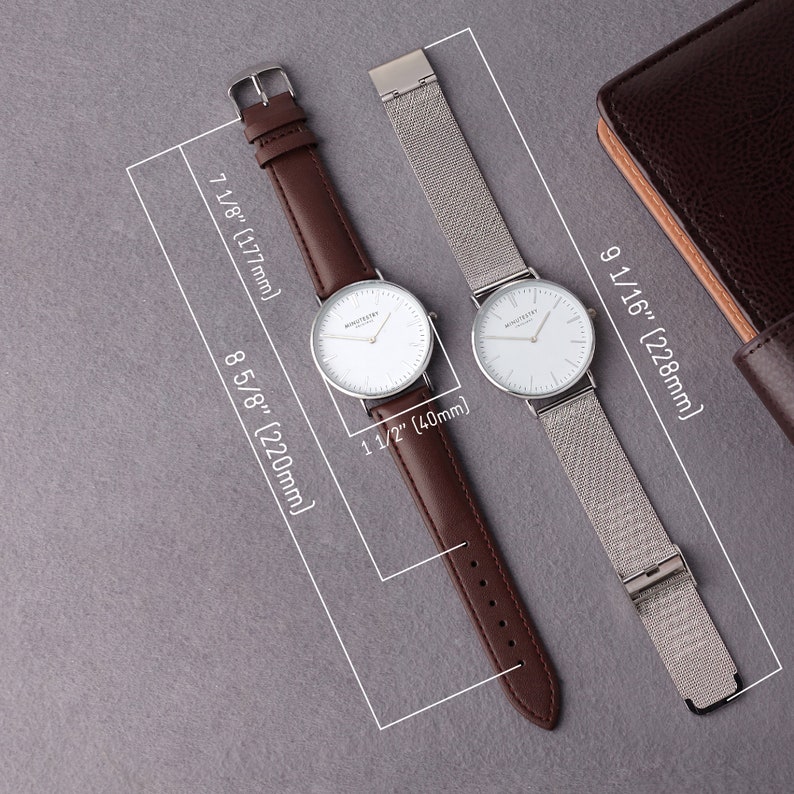May include: Two wristwatches with white faces and silver hands. The watch on the left has a brown leather band, and the watch on the right has a silver mesh band. Both watches are 1 1/2 inches in diameter.