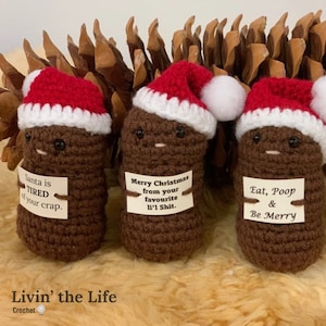 May include: Three crocheted brown poop ornaments wearing Santa hats with funny Christmas-themed messages. The messages read "Santa is TIRED of your crap", "Merry Christmas from your favourite li'l Shit", and "Eat, Poop & Be Merry".