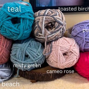 May include: Ten balls of yarn in various colors, including teal, toasted birch, purple, terra cotta, misty green, cameo rose, pink, and pebble beach.