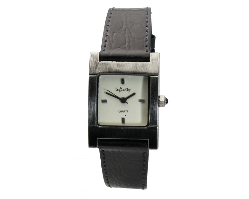 Peut inclure: Une montre-bracelet rectangulaire avec un bo&icirc;tier argent&eacute; et un bracelet en cuir noir. Le cadran de la montre est carr&eacute;, avec le mot "Infinity" en &eacute;criture cursive. La montre est &agrave; quartz.