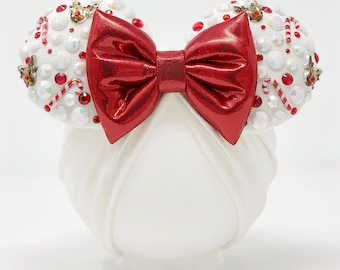 May include: White headband with a red bow and a white and red candy cane design. The headband is decorated with rhinestones and other embellishments.