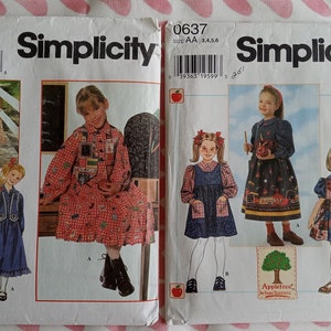 May include: Two Simplicity sewing patterns for children's dresses. The patterns are for sizes 3, 4, 5, and 6. The first pattern features a red and white gingham dress with a patchwork bodice. The second pattern features a blue dress with a red and white gingham pocket and a red and white gingham apron.