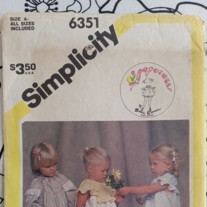 May include: Simplicity sewing pattern number 6351 for three girls' dresses. The pattern is by Betsey  Conn and includes all sizes. The pattern shows three girls wearing the dresses, each holding a bouquet of flowers.