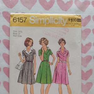 May include: Simplicity sewing pattern number 6157 for a dress. The pattern is for a half-size, size 14 1/2, bust 37. The pattern shows three different versions of the dress, one with a black and white checkered pattern, one with a solid green color, and one with a pink and white polka dot pattern.