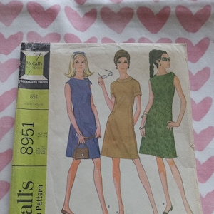 May include: Vintage McCall's sewing pattern for a misses' dress in two versions. The pattern number is 8951, size 16, bust 36. The pattern is for a step-by-step dress.