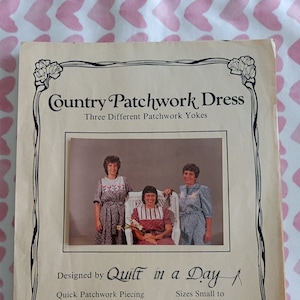 May include: A vintage pattern booklet for a "Country Patchwork Dress" with three different patchwork yokes. The cover features a photo of three women wearing the dress and the text "Designed by Quilt in a Day. Quick Patchwork Piecing, Sewing Instructions, Full Size Patterns. Sizes Small to Extra Extra Large. $5.00. 1955 Diamond, Unit A, San Marcos, CA 92069."