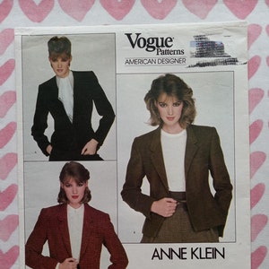 May include: Vogue Patterns American Designer sewing pattern for a blazer by Anne Klein. The pattern number is 2785. The pattern shows three different views of the blazer, one in black, one in brown, and one in a red and black plaid.