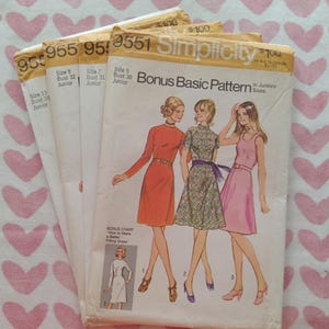 May include: A stack of four vintage Simplicity 9551 sewing patterns for junior sizes. The front cover features illustrations of three dresses in orange, patterned, and pink, with text including Bonus Basic Pattern and size information.