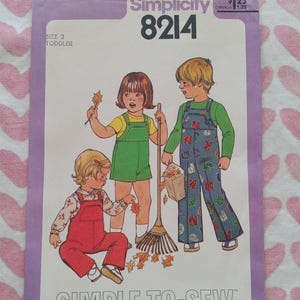 May include: Simplicity 8214 sewing pattern for toddler clothing. The cover art features illustrations of three children wearing overalls and shorts. The text "SIMPLE-TO-SEW" is printed at the bottom of the pattern.
