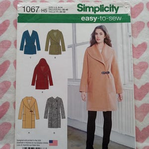 May include: Simplicity pattern 1067 for coats. The pattern features several coat designs, including a wrap coat and a coat with a toggle closure. The pattern includes sizes U.S. 6-14. The cover shows a woman wearing a peach-colored coat.