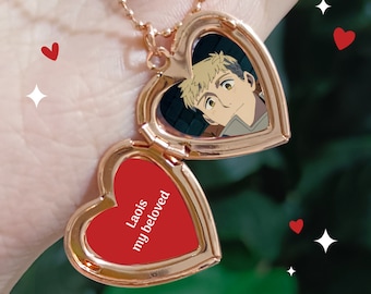 May include: A gold heart-shaped locket necklace with a picture of an anime character inside. The locket opens to reveal a red interior with the words "Laois my beloved" written in white.