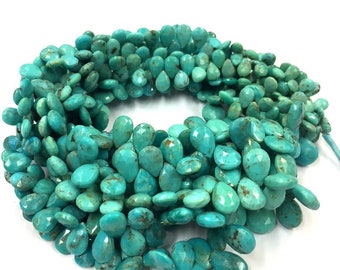 May include: A strand of turquoise gemstone beads in a teardrop shape. The beads are a vibrant blue-green colour with brown markings.