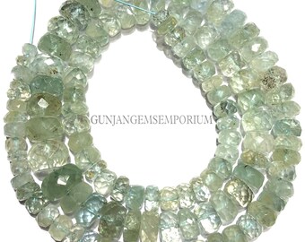 May include: Strands of faceted aquamarine beads in varying shapes and sizes. The beads are a pale blue-green colour and strung on a light blue thread. The beads have a polished, translucent appearance. The image is of a jewellery supply.