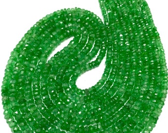 Könnte beinhalten: Eine Strähne grüner Edelsteinperlen, wahrscheinlich Peridot, mit einer facettierten, leicht unregelmäßigen Form. Die Perlen sind auf einer dünnen Schnur aufgefädelt und haben einen Durchmesser von etwa 4 mm. Die Strähne ist etwa 45 cm lang.
