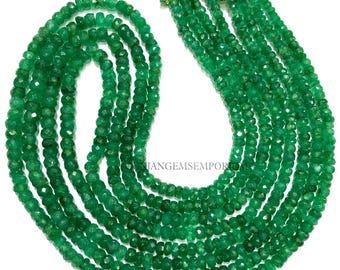 Könnte beinhalten: Eine Kette aus smaragdgrünen Edelsteinperlen, auf einem goldenen Faden aufgefädelt. Die Perlen sind facettiert und haben eine leicht unregelmäßige Form. Die Kette ist etwa 45 cm lang und perfekt für die Herstellung von Schmuck.
