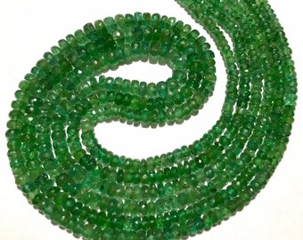 Könnte beinhalten: Eine Kette aus smaragdgrünen Edelsteinperlen. Die Perlen sind facettiert und haben eine leicht unregelmäßige Form. Die Kette ist etwa 45 cm lang.