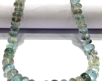 May include: A strand of light blue aquamarine beads, each bead is faceted and has a slightly irregular shape. The beads are strung on a clear thread and are approximately 6mm in diameter.