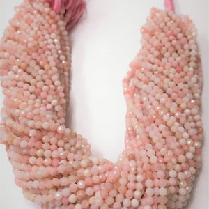 May include: A strand of pink opal beads, approximately 4mm in size, with a faceted finish. The beads are strung on a pink thread and have a natural, slightly irregular shape.
