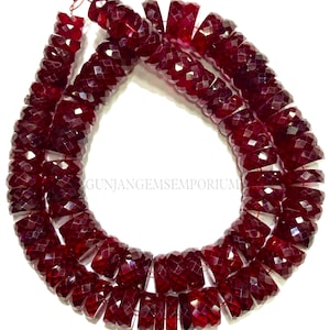 May include: A strand of deep red faceted gemstone beads. The beads are approximately 10mm in diameter and have a polished, faceted finish. The beads are strung on a wire and are ready to be used for jewelry making.