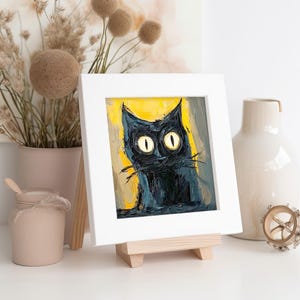 May include: A framed painting of a black cat with large yellow eyes. The cat is looking up and to the right. The background is a yellow and brown abstract design.