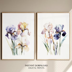 May include: A set of two watercolor prints featuring delicate iris flowers in shades of purple, pink, and yellow. The prints are framed in a simple wooden frame and are perfect for adding a touch of nature to any room.