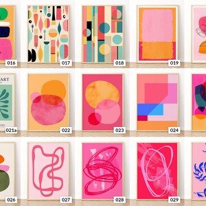May include: A selection of framed abstract art prints. The prints showcase diverse geometric shapes and organic forms in bright colours such as pink, orange, blue, and green. Each print has a unique design, with some including text.