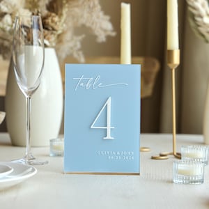 May include: A set of three ceramic mugs with a speckled, matte finish. The mugs are in shades of cream, light gray, and dark gray. Each mug has a simple, minimalist design and a rounded handle.